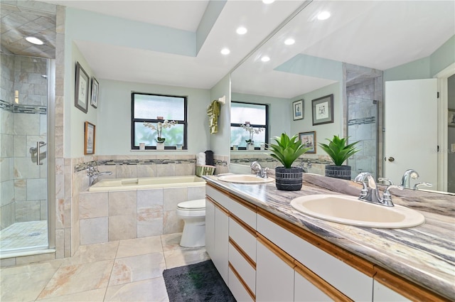 full bathroom featuring vanity, shower with separate bathtub, and toilet