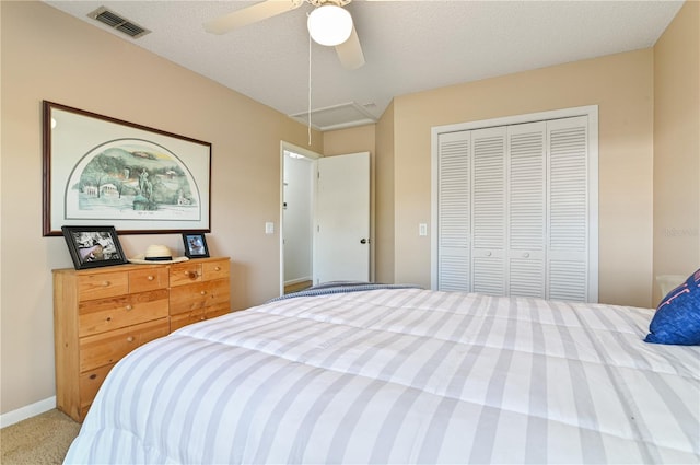 carpeted bedroom featuring ceiling fan, a closet, and a textured ceiling