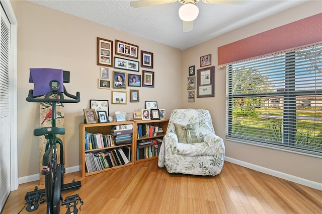 sitting room with a wealth of natural light, hardwood / wood-style floors, ceiling fan, and a textured ceiling