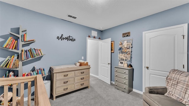 bedroom with visible vents, light colored carpet, a textured ceiling, and baseboards