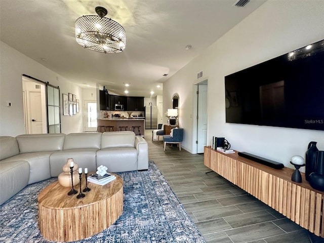 living room featuring an inviting chandelier and a barn door