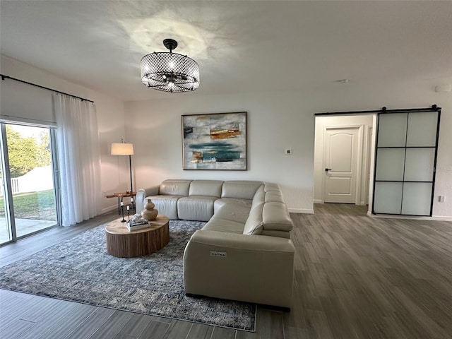 living room with wood-type flooring, a barn door, and a chandelier