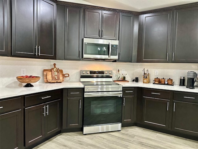 kitchen featuring decorative backsplash, light hardwood / wood-style flooring, and appliances with stainless steel finishes