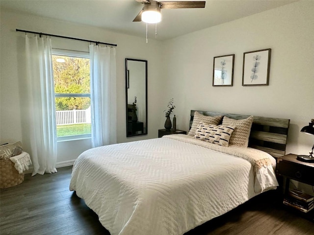 bedroom featuring multiple windows, dark wood-type flooring, and ceiling fan