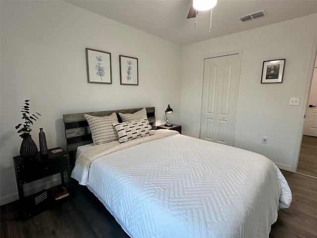 bedroom with a closet, dark hardwood / wood-style floors, and ceiling fan