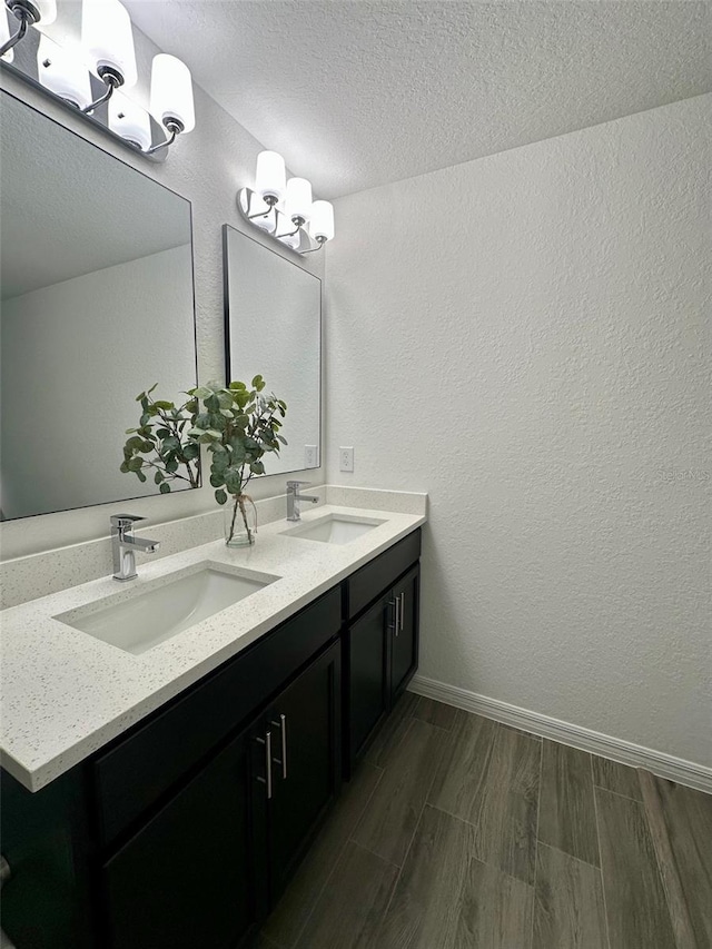 bathroom with vanity, hardwood / wood-style floors, and a textured ceiling