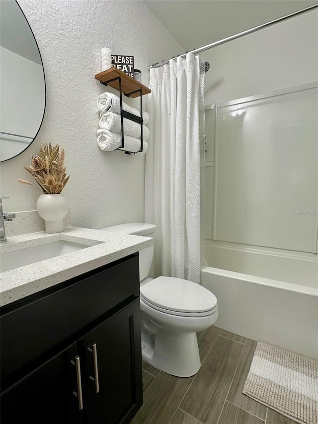 full bathroom with shower / tub combo with curtain, vanity, and toilet