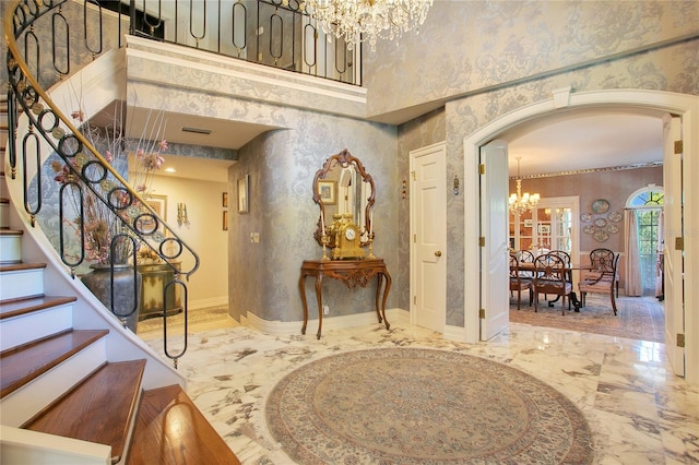 foyer featuring a towering ceiling and a chandelier