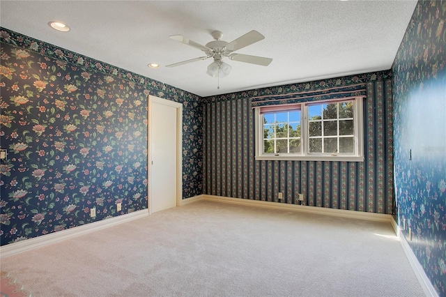 carpeted spare room with ceiling fan and a textured ceiling