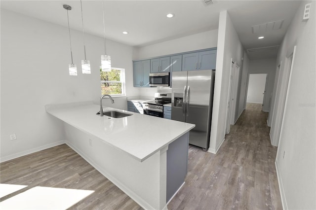 kitchen featuring sink, decorative light fixtures, stainless steel appliances, and kitchen peninsula