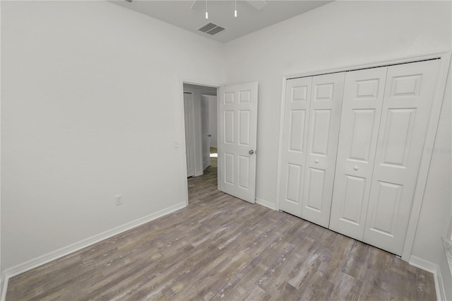 unfurnished bedroom with light hardwood / wood-style floors, a closet, and ceiling fan