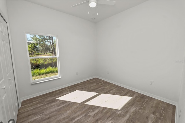 spare room with dark wood-type flooring and ceiling fan