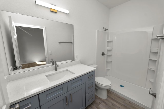 bathroom with walk in shower, wood-type flooring, toilet, and vanity