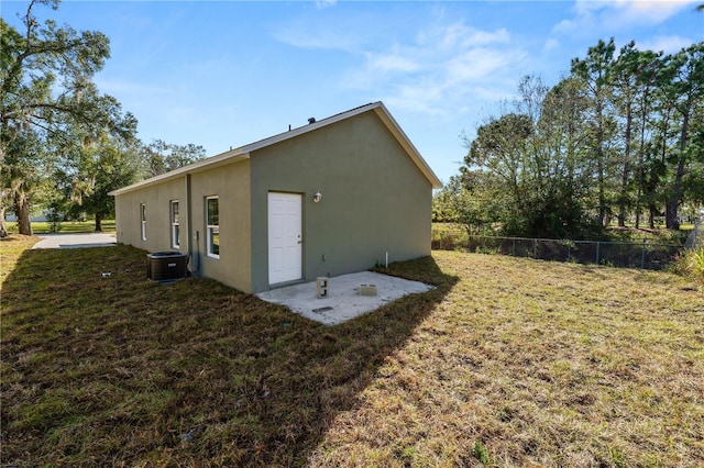 rear view of house featuring a yard and central air condition unit