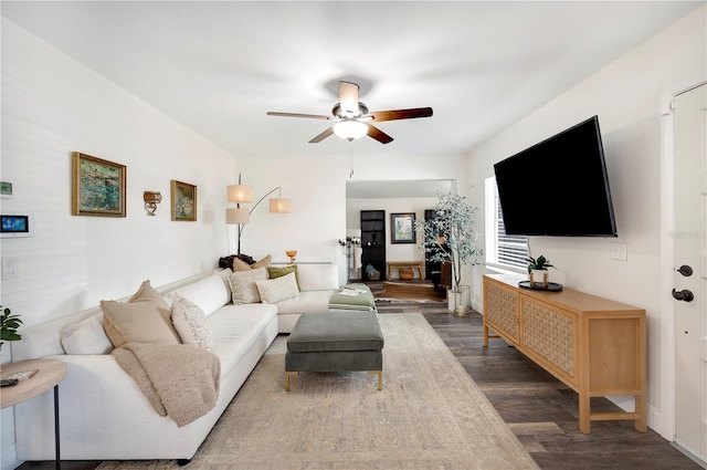 living room featuring dark wood-type flooring and ceiling fan