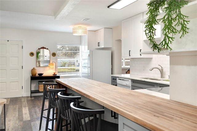 kitchen with sink, white appliances, tasteful backsplash, white cabinets, and wood counters