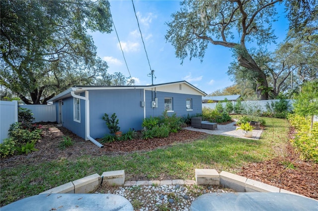 rear view of property with a yard and a patio area