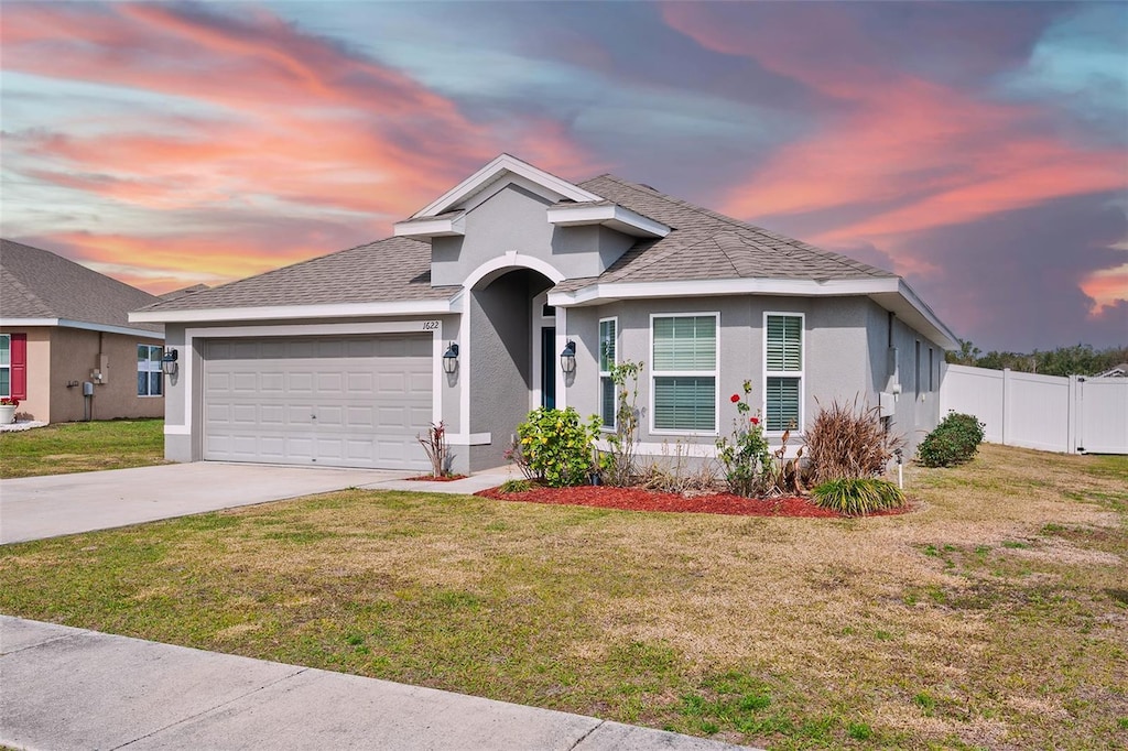 view of front of property featuring a garage and a yard