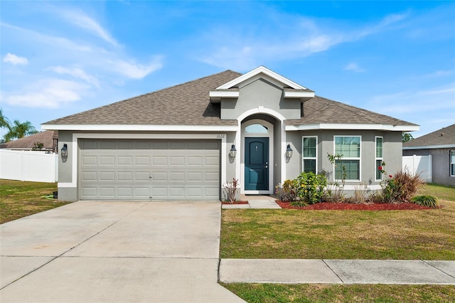 view of front of house with a garage and a front lawn