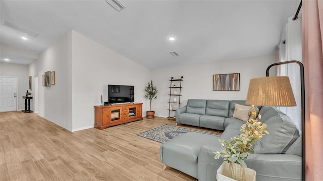 living room featuring lofted ceiling and light wood-type flooring