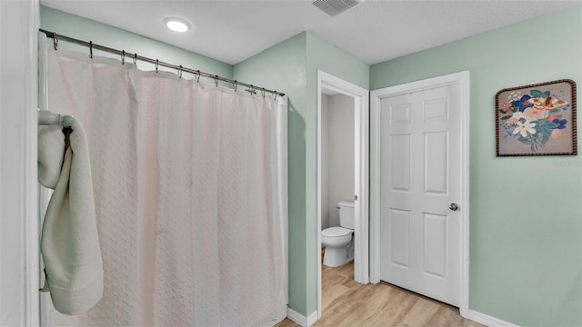 bathroom featuring hardwood / wood-style floors and toilet