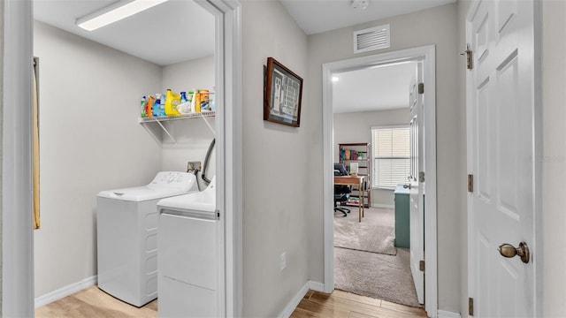 washroom featuring washing machine and dryer and light hardwood / wood-style floors