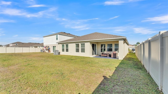 rear view of property featuring a yard and central air condition unit