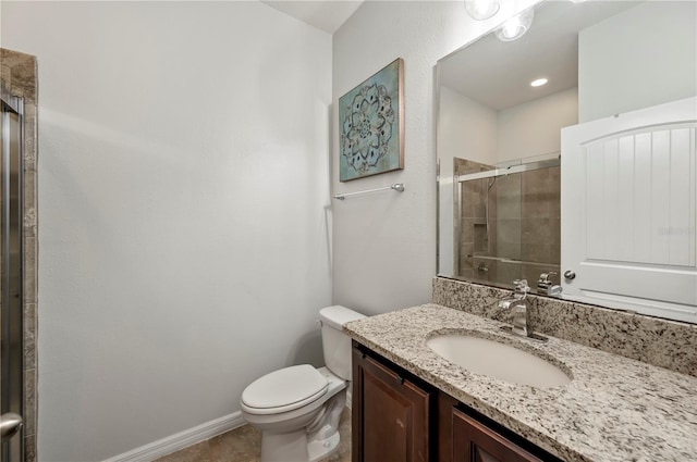 bathroom with a shower with door, vanity, and toilet