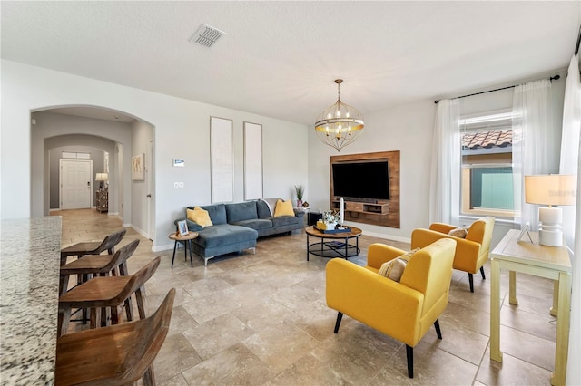 living room with a textured ceiling and a notable chandelier