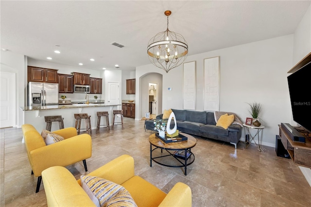 living room with a chandelier and sink