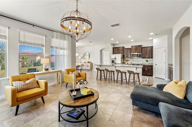 living room with a chandelier and a textured ceiling