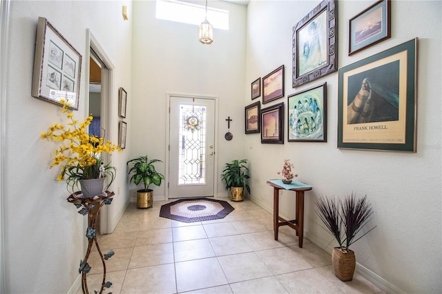 tiled entryway with a towering ceiling and a healthy amount of sunlight