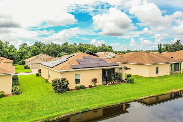 back of house with a lawn, a sunroom, and solar panels