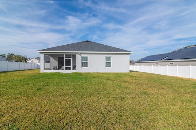 back of property with a sunroom and a yard