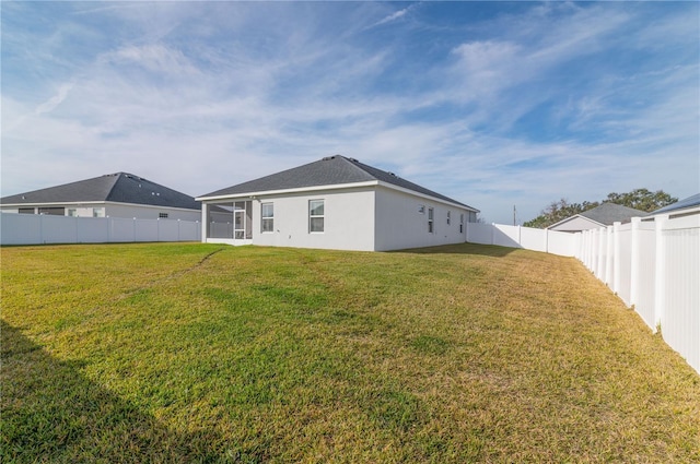 rear view of property featuring a yard