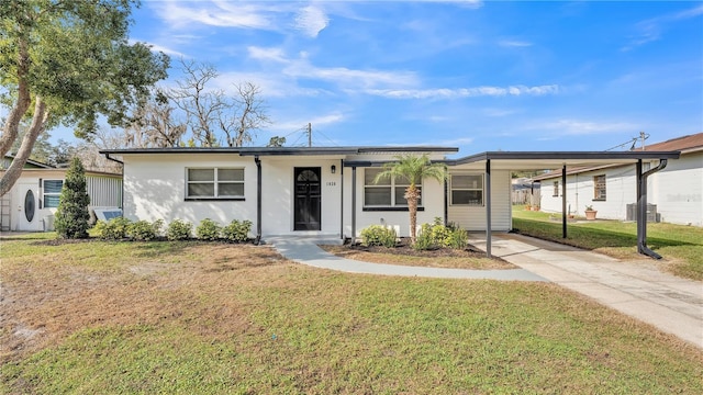 ranch-style home with a front yard, a carport, and central air condition unit