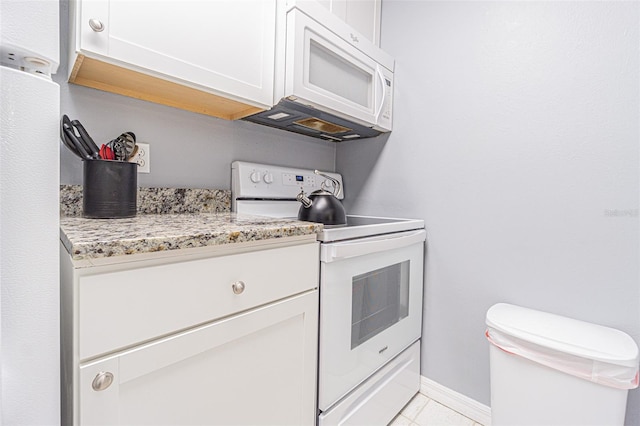 kitchen with white cabinetry, light stone countertops, and white appliances