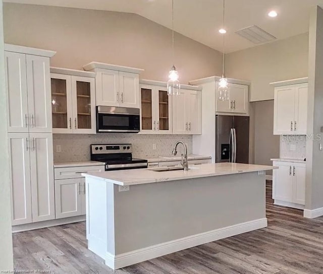 kitchen with sink, decorative light fixtures, appliances with stainless steel finishes, an island with sink, and white cabinets