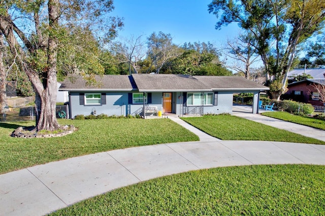 ranch-style home featuring a carport and a front lawn