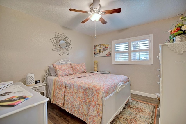 bedroom with dark wood-type flooring, ceiling fan, and a textured ceiling