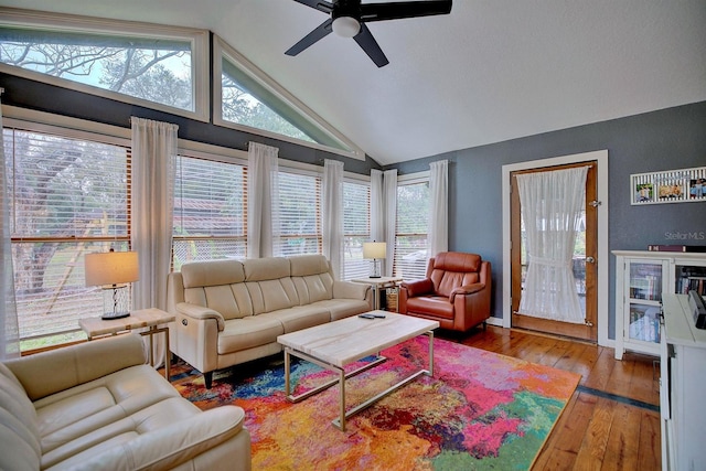 living room featuring hardwood / wood-style flooring, ceiling fan, and vaulted ceiling