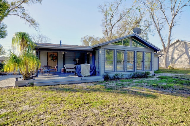 rear view of property with a yard and a deck