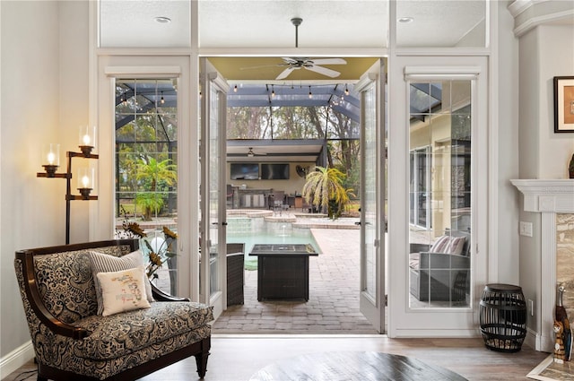 doorway with ceiling fan and light hardwood / wood-style floors