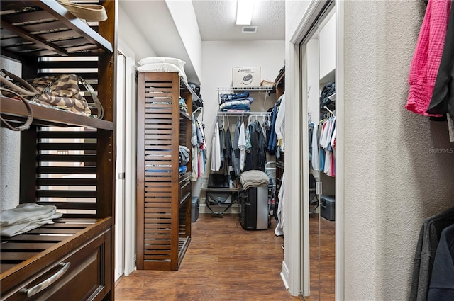 spacious closet featuring dark hardwood / wood-style flooring