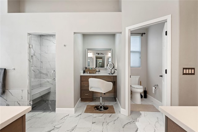 bathroom featuring vanity, toilet, and an enclosed shower