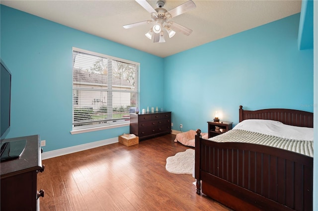 bedroom with dark hardwood / wood-style floors and ceiling fan