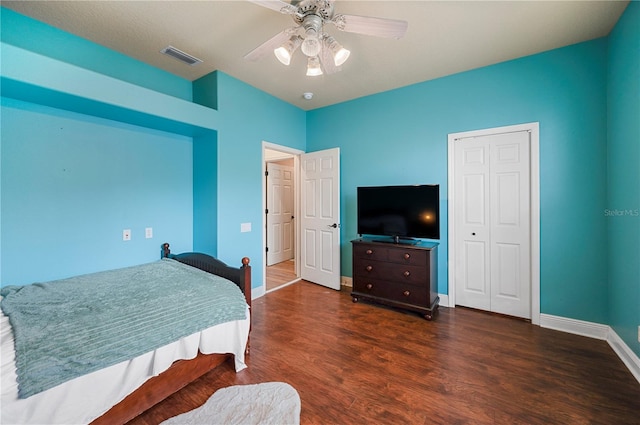 bedroom with a closet, dark hardwood / wood-style floors, and ceiling fan