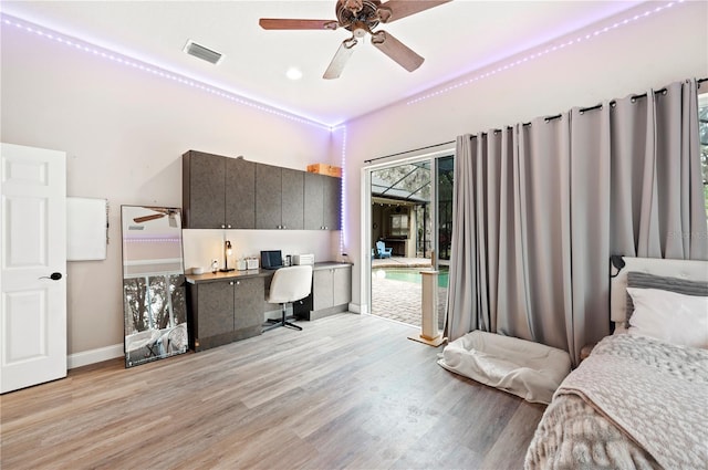 bedroom featuring ceiling fan, built in desk, access to exterior, and light hardwood / wood-style floors