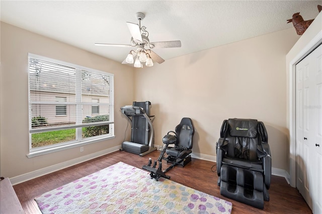 workout area with dark hardwood / wood-style flooring and ceiling fan