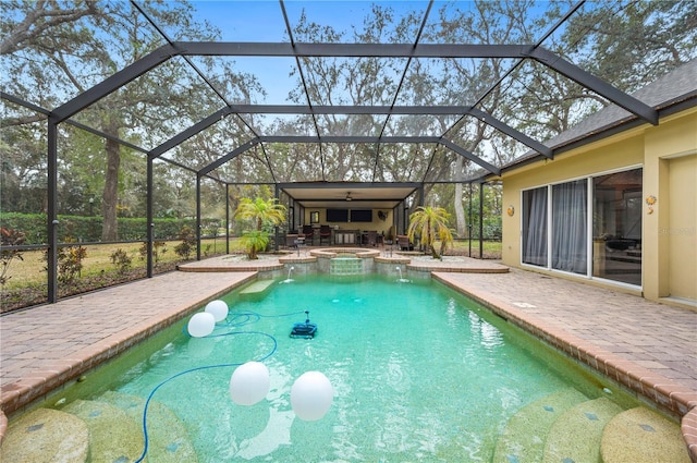 view of swimming pool featuring an in ground hot tub, ceiling fan, glass enclosure, and a patio area